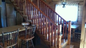 A wooden staircase with a railing leading to a dining area with a table and chairs. - Mt Princeton Escape 1 Bedroom Holiday Home By Pinon Vacation Rentals (Nathrop)