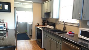 A kitchen with wooden flooring, a sink, cabinets, a stove, and a microwave. - Nita s Place 2 Bedroom Holiday Home By Pinon Vacation Rentals (Salida)