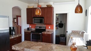 A kitchen with wooden cabinets, a microwave, a stove, and a coffee maker. - River City Town House 3 Bedroom Holiday Home By Pinon Vacation Rentals (Salida)