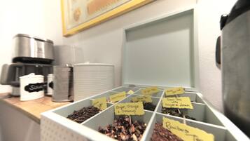 Angolo caffè con contenitori etichettati di diverse varietà di tè.