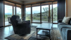 A spacious living room with a large window, a ceiling fan, and a view of the outdoors. - River Time 1 Bedroom Holiday Home By Pinon Vacation Rentals (Salida)