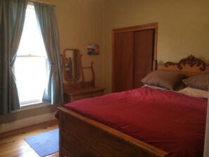A bedroom with a wooden bed, a wooden dresser, a mirror, and a window with curtains. - Salida Bungalow 2 Bedroom Holiday Home By Pinon Vacation Rentals (Salida)