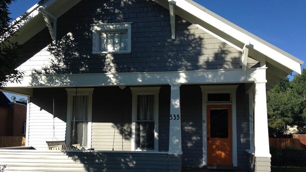 A two-story house with a front porch, a door with a number 335, and a small front yard.