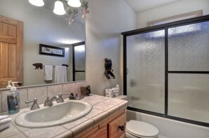 A bathroom with a large sink, a toilet, and a shower enclosure.