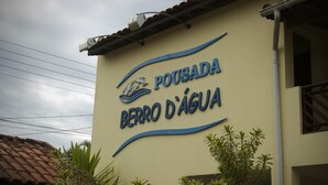 Letrero de 'Pousada Berru D'Água' con un logotipo de un velero y olas.