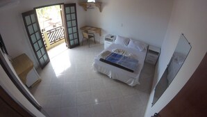 Un dormitorio con cama, escritorio, silla y ventilador de techo.