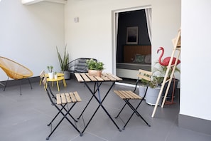 An outdoor patio with a wooden table and chairs, potted plants, and a wooden ladder. - Curù (Castellammare del Golfo)