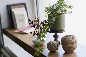 A wooden table with a potted plant, a small vase, and a ball of twine. - Curù (Castellammare del Golfo)
