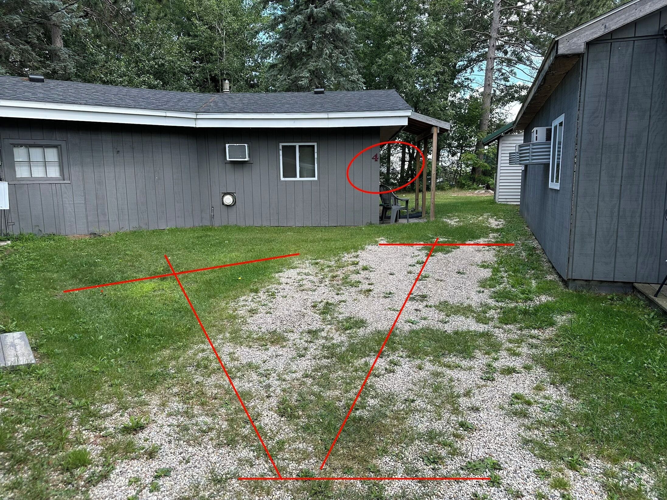 A residential area with a house, a covered outdoor seating area, and a gravel path.