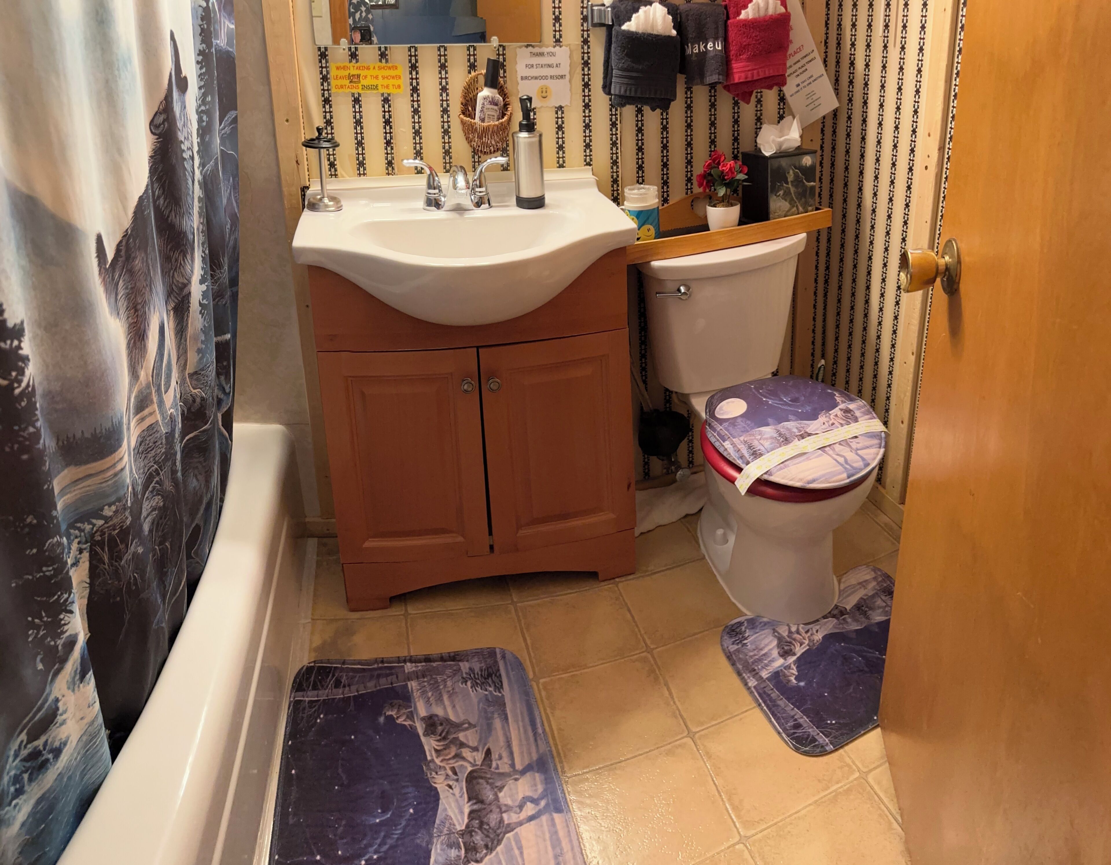 A bathroom with a sink, toilet, and shower curtain.
