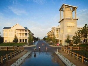 A hotel with a central courtyard, a swimming pool, and a tall tower structure. - Morning Glory 203 (Port St. Joe)