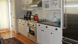 A kitchen with white cabinets, stainless steel appliances, a toaster, a kettle, and a blender. - Morning Glory 303 (Port St. Joe)