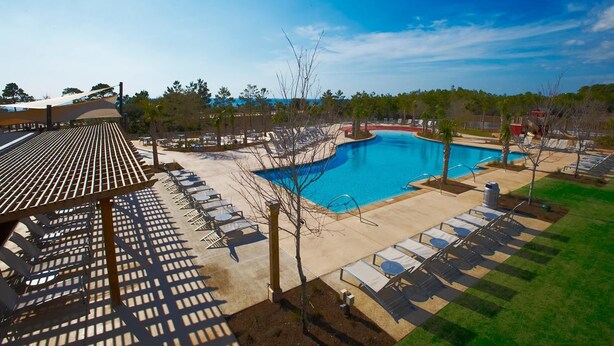 A pool area with sun loungers and a covered seating area. - Morning Glory 305 (Port St. Joe)