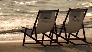 Two beach chairs with "The Magic" written on them, placed on a sandy beach with the ocean in the background. - Morning Glory 309 (Port St. Joe)