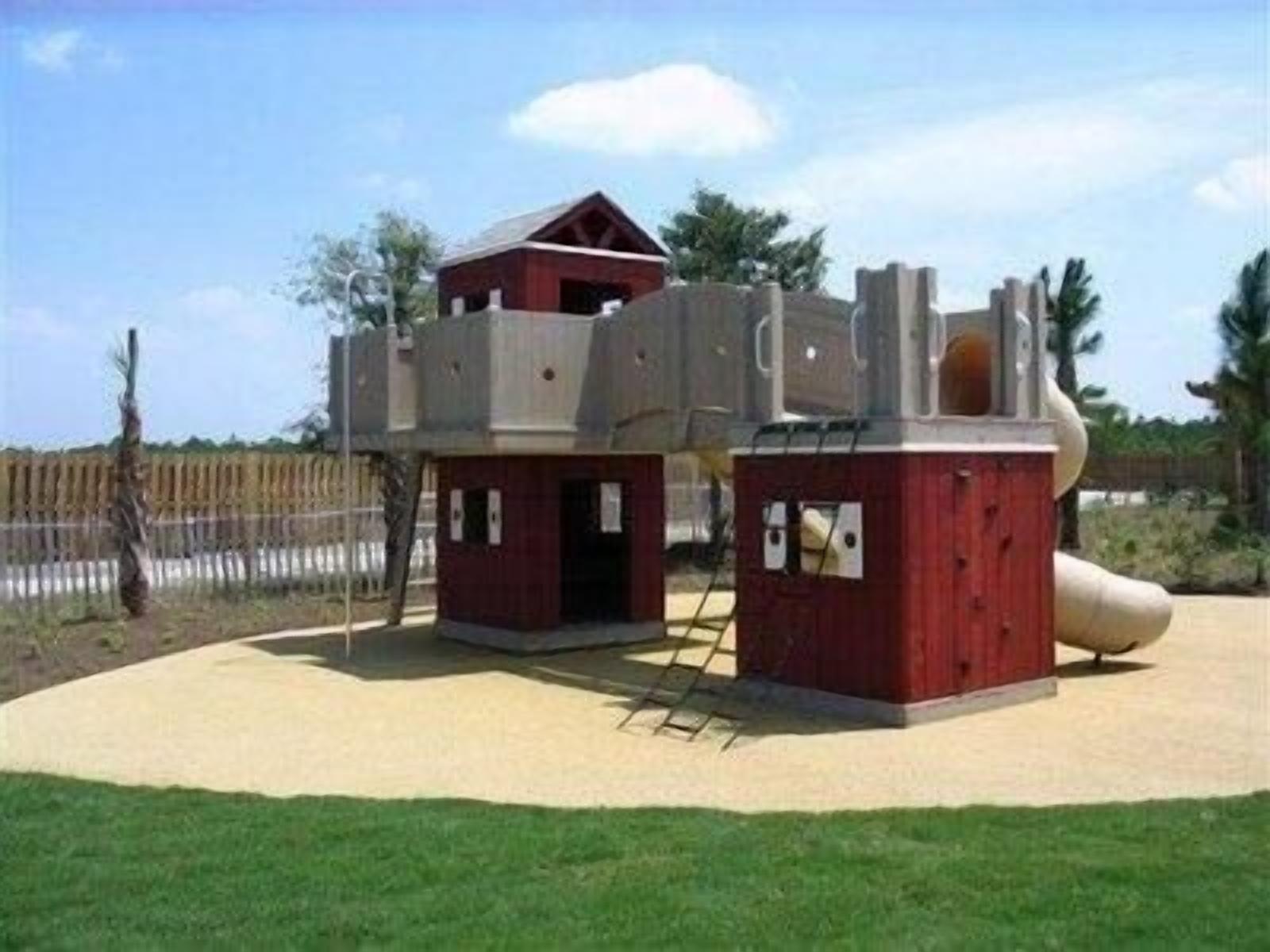 A playground with a slide, climbing structures, and a covered area.