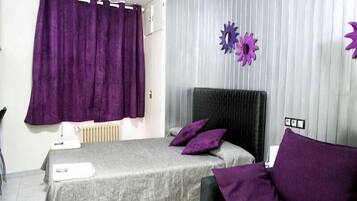 Une chambre à coucher avec un lit, des rideaux violets et des éléments décoratifs sur les murs.