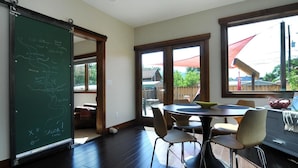 A room with a blackboard, a round table with chairs, and large windows. - Salida Modern 3 Bedroom Holiday Home By Pinon Vacation Rentals (Salida)