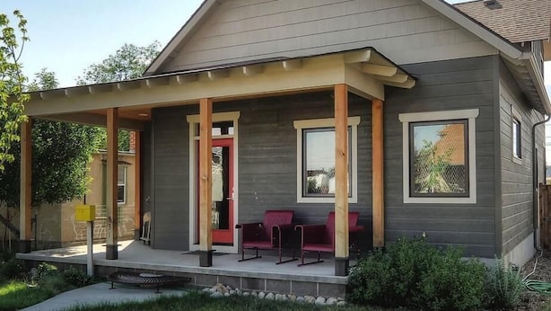 A modern two-story house with a covered porch, a red door, and a small outdoor seating area. - Salida Modern 3 Bedroom Holiday Home By Pinon Vacation Rentals (Salida)