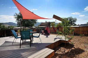 A wooden deck with outdoor furniture, a hammock, and a small tree planter. - Salida Modern 3 Bedroom Holiday Home By Pinon Vacation Rentals (Salida)