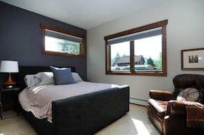 A bedroom with a large bed, two windows, a chair, and a lamp. - Salida Modern 3 Bedroom Holiday Home By Pinon Vacation Rentals (Salida)
