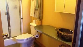 A bathroom with a toilet, a shower, and a sink.