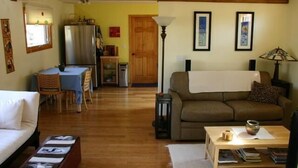 Un salon comprenant un canapé, une table basse et un coin repas avec une table et des chaises.