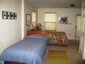 A bedroom with a single bed, a nightstand, a lamp, and a window with blinds. - Villa on the Green 2 Bedroom Holiday Home By Pinon Vacation Rentals (Salida)