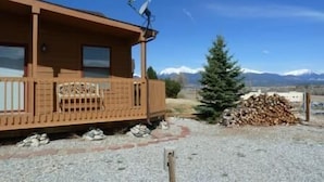 A wooden cabin with a balcony, a satellite dish, and a mountain view. - Villa on the Green 2 Bedroom Holiday Home By Pinon Vacation Rentals (Salida)