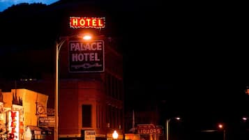 Um hotel chamado "Palace Hotel", com uma placa indicando que é um "HOTEL" e "PALACE HOTEL" em letras iluminadas.
