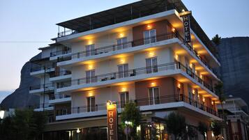 Vista frontal de la propiedad por la tarde o noche