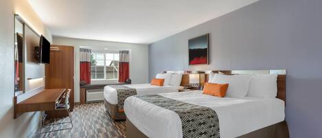 A hotel room with two beds, a desk, a TV, and a window with curtains.