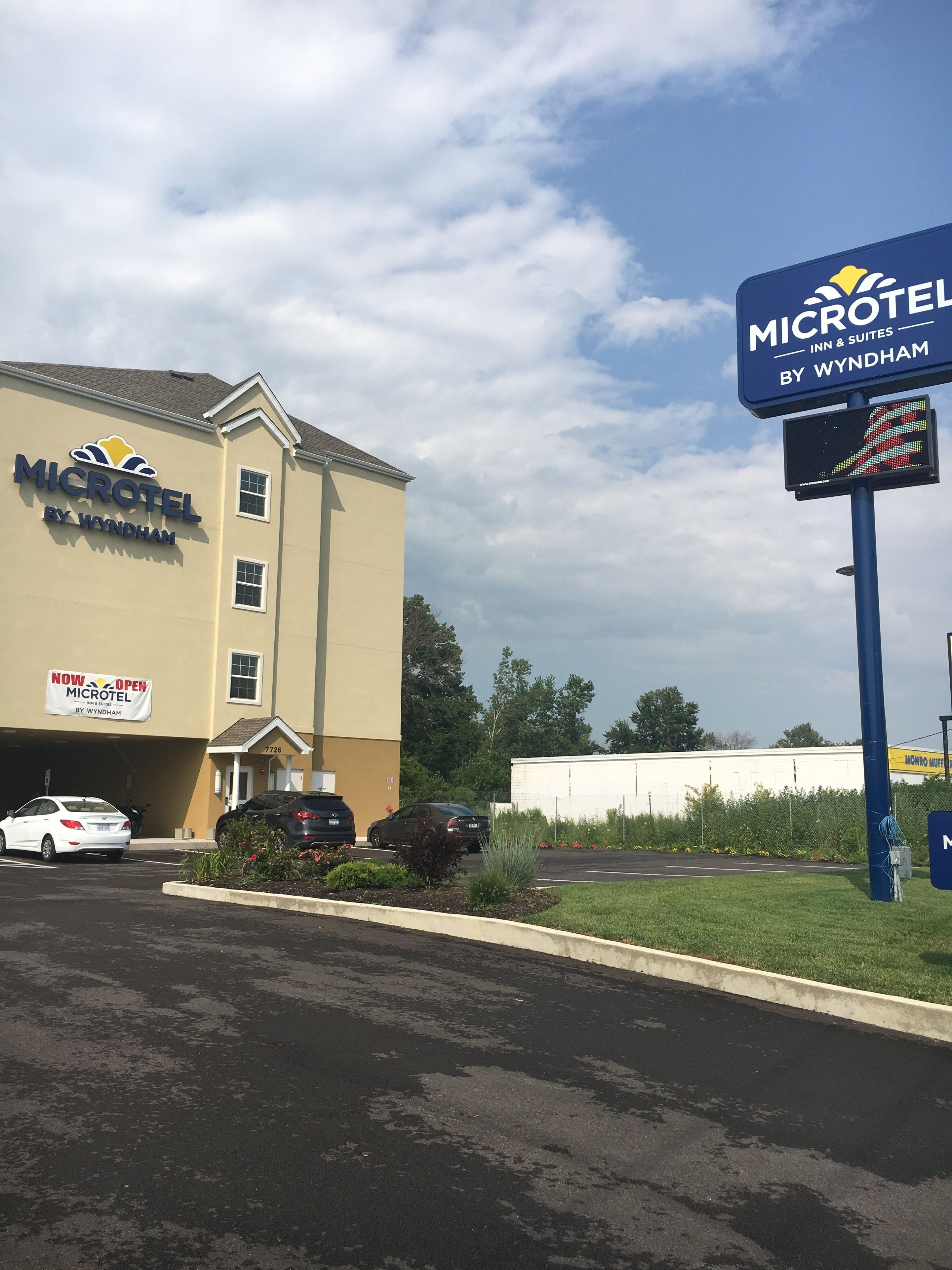 Un hôtel Microtel Inn & Suites de la chaîne Wyndham, doté d’un parking et d’un grand panneau indicateur.
