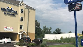 Un hôtel Microtel Inn & Suites de la chaîne Wyndham, doté d’un parking et d’un grand panneau indicateur.