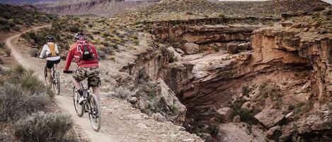 A rugged mountain biking trail with rocky terrain and sparse vegetation.