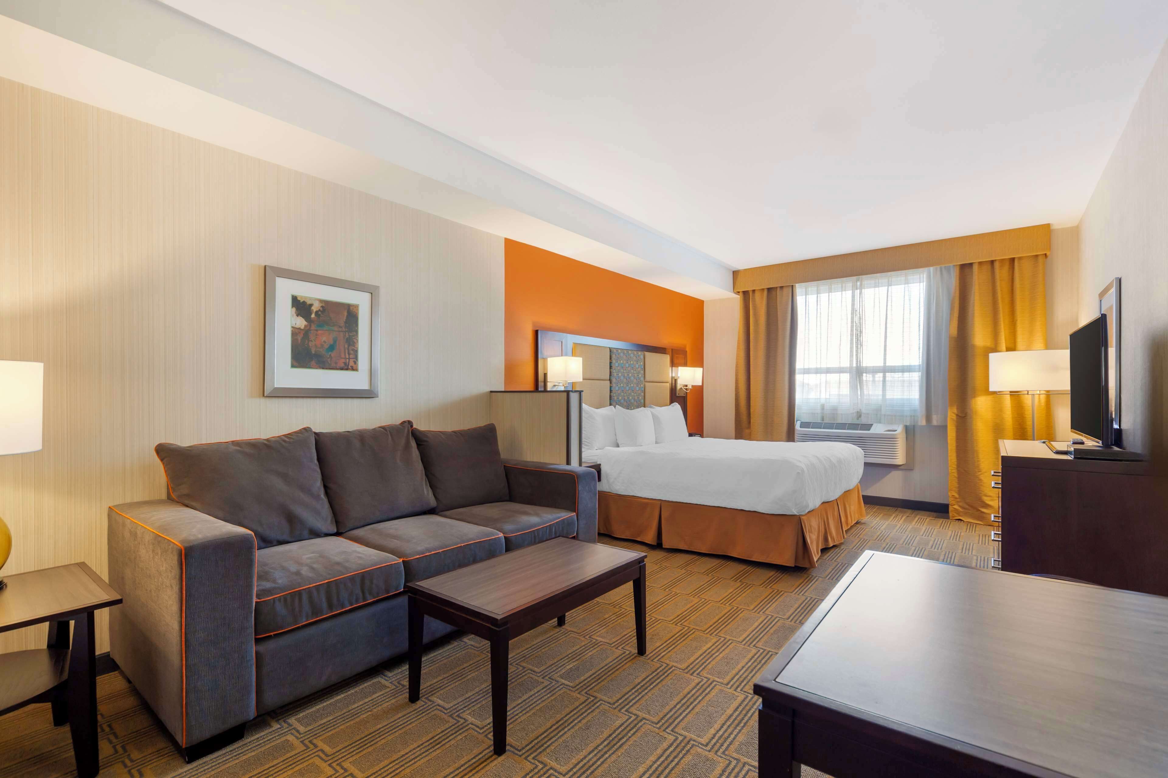 Senger med overmadrass, safe på rommet, skrivebord og blendingsgardiner