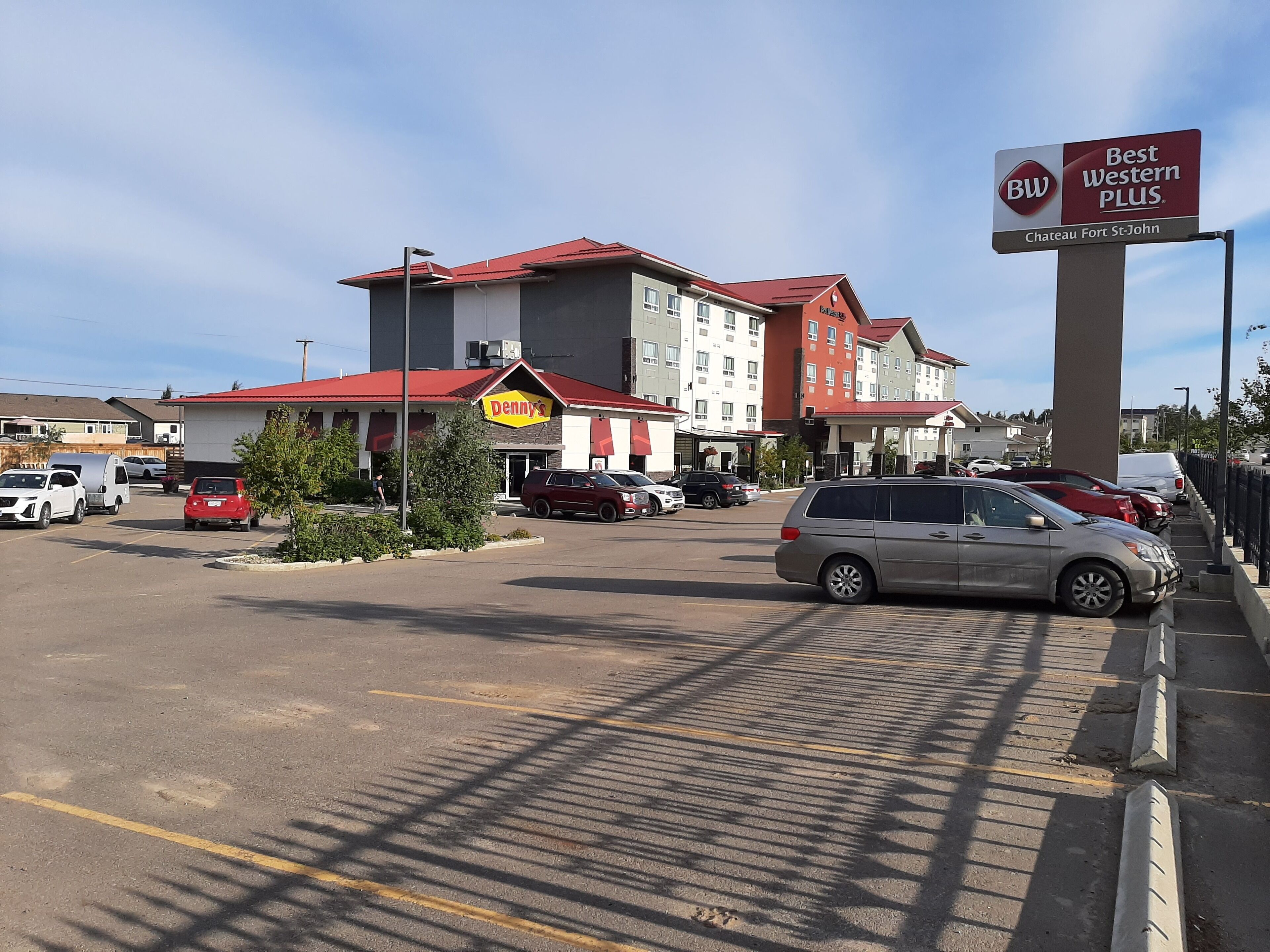 A parking lot with a Denny's restaurant and a Best Western Plus sign.