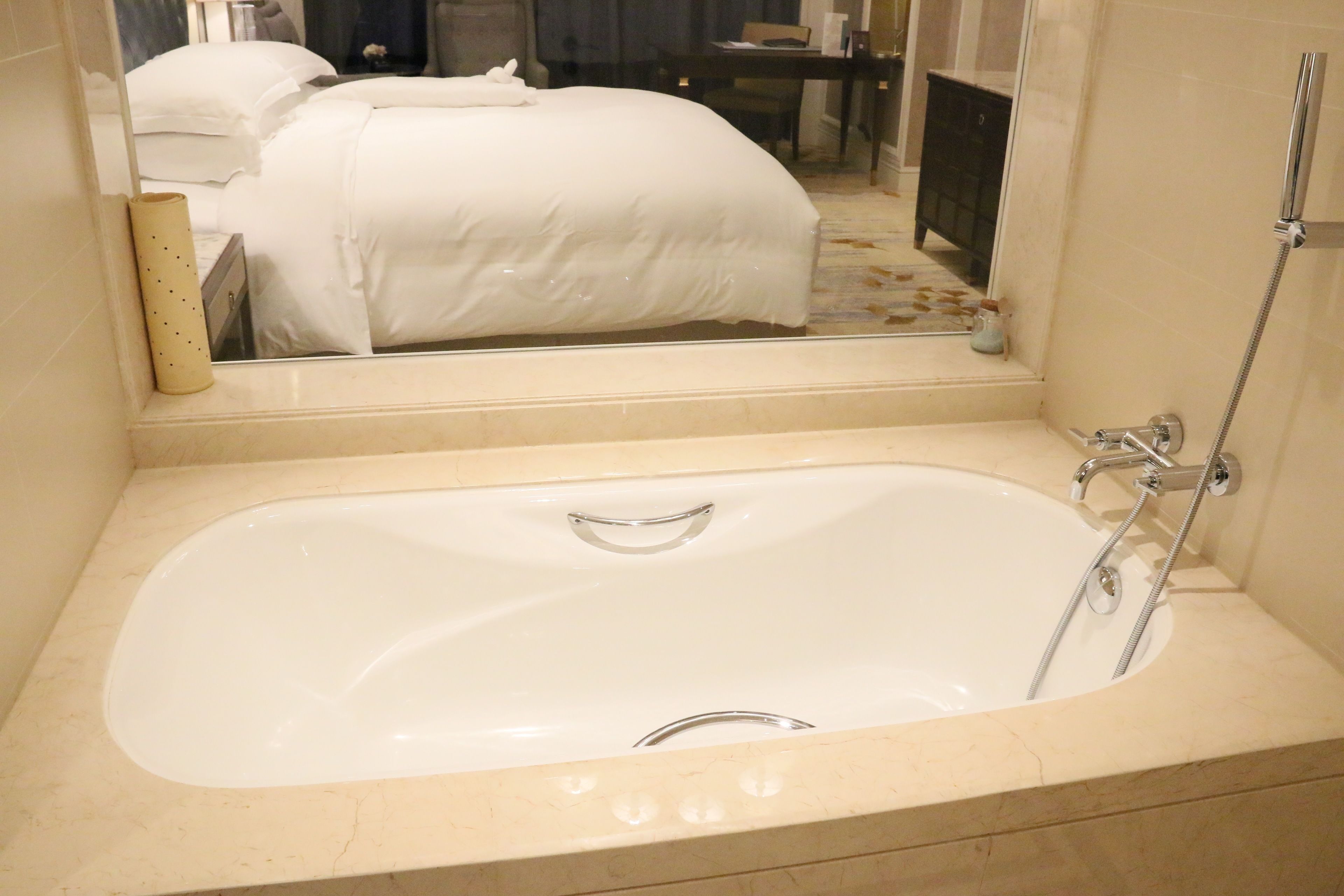 Une salle de bain avec une grande baignoire, un miroir et un espace douche.