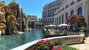 Une grande piscine intérieure agrémentée d’une cascade, entourée de formations rocheuses imposantes et d’un pont.