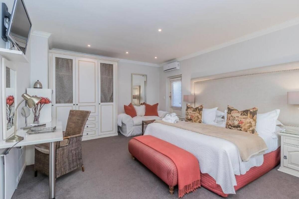 Ein Schlafzimmer mit Bett, Nachttischen, Schreibtisch und Stuhl.