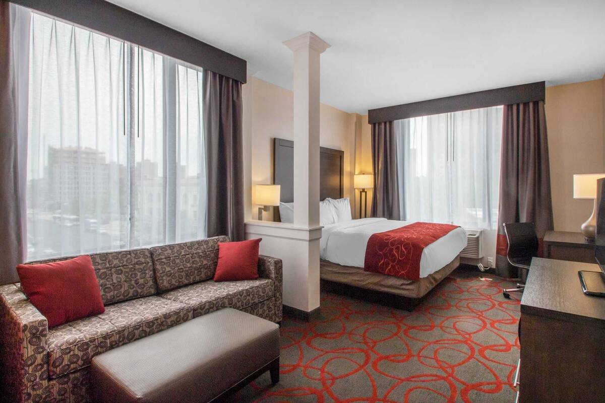 Una habitación de hotel con sofá, cama, escritorio y silla.