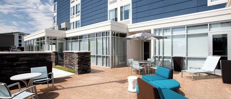 An outdoor patio area with seating, a table, and a large umbrella.