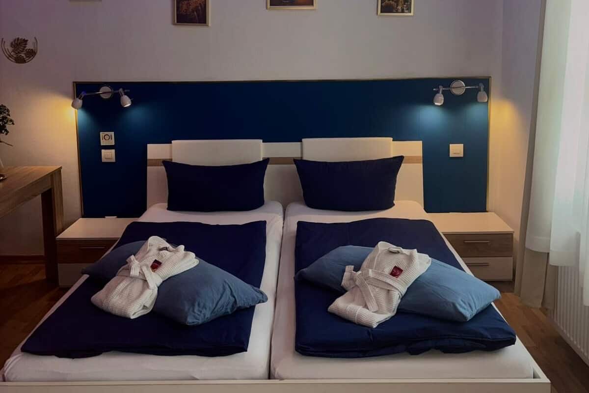 Ein Doppelbett mit Kopfteil, Nachttischen und Wandleuchten.