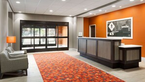 A hotel lobby with a reception desk, seating area, and a large window. - Hampton Inn North Olmsted Cleveland Airport (North Olmsted)