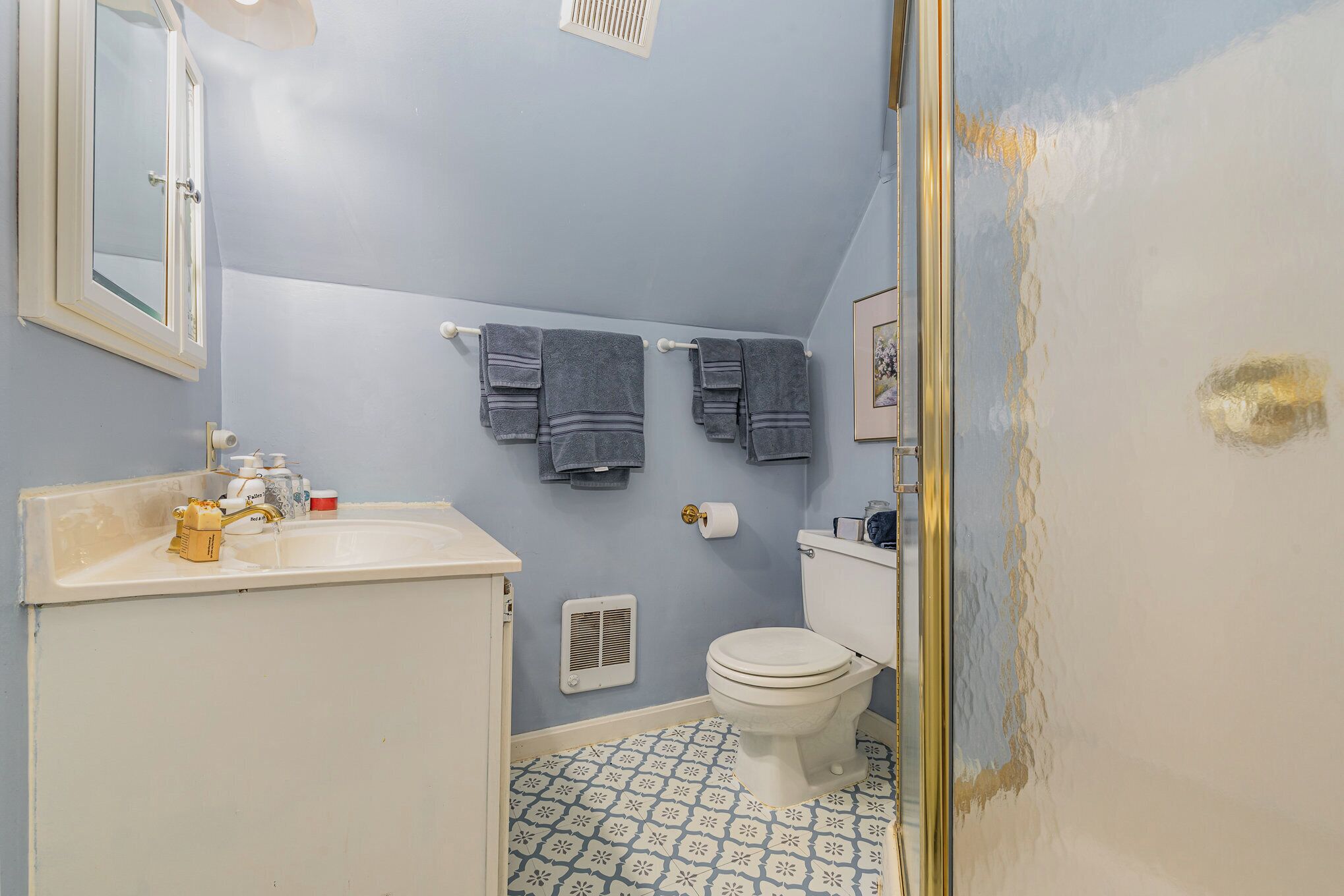 Une salle de bain équipée de toilettes, d’un lavabo et d’un porte-serviettes.