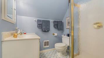 Une salle de bain équipée de toilettes, d’un lavabo et d’un porte-serviettes.