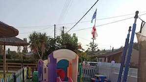 A playground with slides and a climbing structure. - Amadeus Hawaii Studios Apts (Corfu)