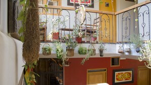 Een meerlaags interieur met balkons, potplanten en een houten leuning.