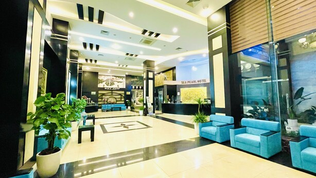 A hotel lobby with a reception desk, seating area, and a gift shop.