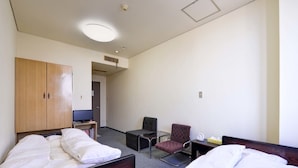 A hotel room with two beds, a desk, a chair, and a wardrobe. - Okubo Ryokan (Komatsu)