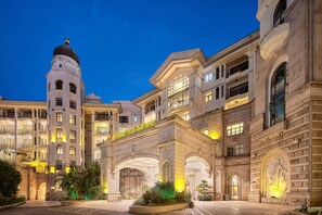 A historic building with a prominent tower, large arched entrance, and multiple balconies. - Yang Jiang Country Garden Phoenix Hotel (Yangjiang)